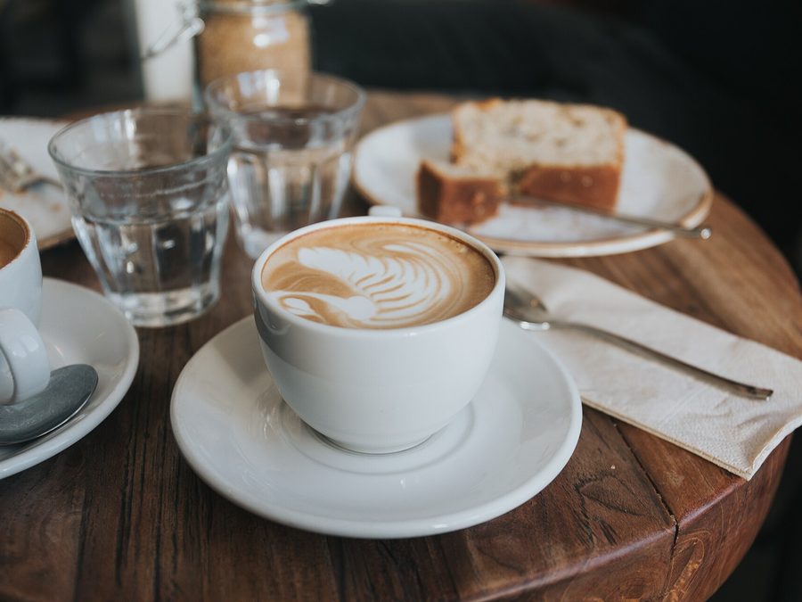 木のテーブルに並ぶコーヒーとケーキ